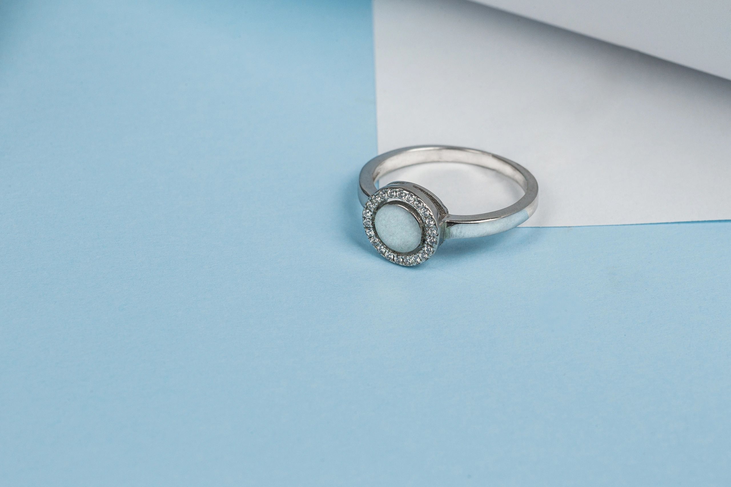 Elegant silver ring with gemstones on blue background